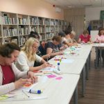 Dalyvės kruopščiai kuria atvirukus