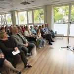 Pilna salė susirinkusiųjų klausosi aktoriaus skaitomų eilių ir atliekamų kūrinių